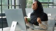 © Yuliia - Happy Muslim business woman win with computer Arabian businesswoman female girl worker employer winning victory success with pc in office Islamic lady achieve good result internet company web growth