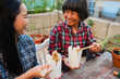 © DisobeyArt - Asian mother and daughter eating together instant noodles outdoor at home terrace - Family lifestyle and food concept - Main focus on mum face