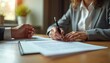 © miss irine - Woman signs contract with pen at desk in office. Business agreement completed. Paperwork signing. Partner awaits signature. Successful business transaction. Loan approval, financial commitment. New