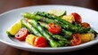 © Дмитрий Баронин - Grilled asparagus and corn with cherry tomatoes and lime wedges on a white plate, showcasing vibrant colors and fresh ingredients for healthy eating