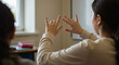 © Tamaras Pictures 4U - Woman using sign language while communicating in classroom setting