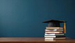 © Vadym - Black graduation cap with golden tassel rests on stack of various textbooks. Dark wooden desk sits against deep blue background, providing ample copy space. Image academic success, higher education