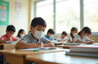 © Pete - Elementary students return to classroom after pandemic lockdown. Young pupils wear face masks while studying at desks in bright indoor space. Focus on safety, education during post-lockdown learning.