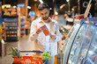 © Serhii - Man shopping for fish examining food label in supermarket