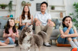 © Kawee - Asian family sit together on sofa with their pet in living room at home.