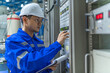 © reewungjunerr - Electrical engineer woman checking voltage at the Power Distribution Cabinet in the control room,preventive maintenance Yearly,Thailand Electrician working at company