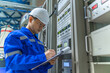 © reewungjunerr - Electrical engineer woman checking voltage at the Power Distribution Cabinet in the control room,preventive maintenance Yearly,Thailand Electrician working at company