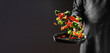 © Надія Коваль - Chef tossing fresh broccoli and carrot slices into a hot grill pan in mid-air action on dark background with copy space for culinary advertising