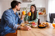 © Impact Photography - Couple drinking fresh orange juice while having breakfast at home