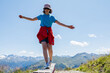 © Elena Medoks - Young girl balancing on wooden beam in mountain landscape