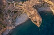 © AmazingAerialAgency - Aerial view of Bronze Age village ruins standing in stark contrast to the turquoise waters around Capo Milazzese, Panarea, Sicily, Italy.