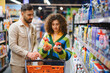 © Serhii - Couple shopping for cleaning supplies in supermarket aisle