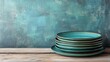 © aoy - Teal ceramic plates stacked on rustic table