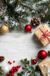 © wolfhound911 - Snowy winter frame formed by frost-covered pine branches, gift boxes, and festive ornaments with red berries