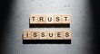 © Musfiqur - Trust issues' concept with wooden blocks on grey textured surface.