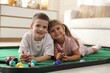 © New Africa - Cute kids on golf pool table at home