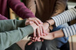 © Mediaphotos - Diverse group of young and adult people stacking hands in gesture of unity during group therapy session, multiethnic people supporting each other in teamwork