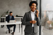 © Novak - African American Businesswoman Using Smartphone in Office