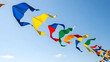 © NAZ - Colorful kites soaring high against a bright blue sky