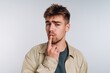 © bodnarphoto - Young man with a thoughtful expression touching his lips.
