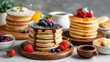 © mikhailberkut - Stack of fluffy pancakes with chocolate syrup and fresh berries. Sweet breakfast food with blueberries, raspberries and mint on wooden table. Homemade dessert concept