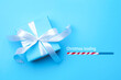 © New Africa - Christmas expectation. Candy cane as loading bar. Gift box on light blue background, top view