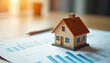 © Viktor - House model stands on finance chart. Concept of real estate market analysis, investment strategy. Property value determination, home loan mortgage, economic growth forecast. Housing price