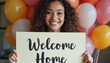 © Khelga Volkova - Smiling woman holding welcome home sign with colorful balloons