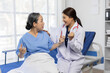 © Wasan - Female doctor sitting on a hospital bed, comforting an elderly patient while sharing encouraging news about her health, fostering trust and hope during a critical moment.