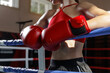 © st.kolesnikov - Female boxer resting on ring ropes during training break