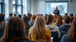 © janzwolinski - Audience listens attentively during a presentation in a lecture hall setting