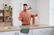 © Pixel-Shot - Young man with paper bag using mobile phone in kitchen. Food delivery service