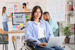 © Pixel-Shot - Female designer in wheelchair working with laptop at office
