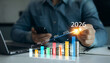 © Mer_Studio - Businessman analyzing financial growth chart for 2026 year.Showing revenue increase, market trends, investment strategy, economic progress, success and future business development in 2026