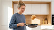 © smth.design - Smiling woman flipping pancake in modern bright kitchen while cooking breakfast in casual cozy home environment