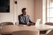© Jelena - Professional Man in Suit Working on Laptop in Modern Office