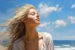 © V Art - Young woman enjoying fresh ocean breeze with hair flowing freely under a bright blue sky during a sunny day at the beach