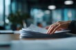 © Asier - Close-up of Colombian accountant reviewing receipts with safe hand angle.