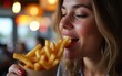 © Christian - Close-up of woman eating French fries in a pub. High quality