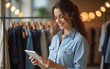 © Madison - Portrait Of Female Owner Of Fashion Store Using Digital Tablet To Check Stock In Clothing Store. High quality