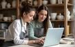 © Madison - Young female ceramists using a laptop together in their store. High quality