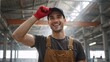© Vasiliy - Portrait of a happy industrial worker smiling in a factory. Cheerful young male employee in overalls and cap at his job