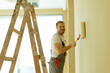 © BGStock72 - Happy painter applying fresh coat of paint in modern interior space during daytime