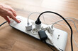 © Proxima Studio - Person is plugging in a device to a power strip