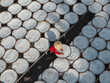 © AmazingAerialAgency - Aerial view of a worker in a conical hat tending to numerous trays filled with white contents, creating a geometric pattern of light and shadow, Tay Ninh, Tay Ninh, Vietnam.