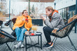 © Soloviova Liudmyla - Mother with adult son sitting on the open terrace in a coffee shop, drinking coffee and having a lovely conversation. Late autumnal days in Europe.