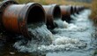 © miss irine - Industrial pipes spill dirty liquid waste into natural stream. Water contamination from industrial outflow affects ecosystem. Environmental hazard, pollution problem. Chemical discharge ruins