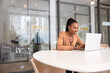 © fizkes - Positive engaged young Black project manager woman typing on laptop in modern office interior with glass wall, managing online business process, using Internet technology for productivity