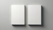 © Pete - Two white blank hardcover books rest side by side on a plain gray surface. Ideal for mockups, these empty books offer ample space for custom cover designs, titles, or branding.