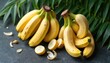© Pete - Ripe yellow bananas piled on dark surface with green palm leaves in background. Bananas partially peeled, revealing white flesh. Sliced lemons add citrus touch to tropical fruit arrangement.